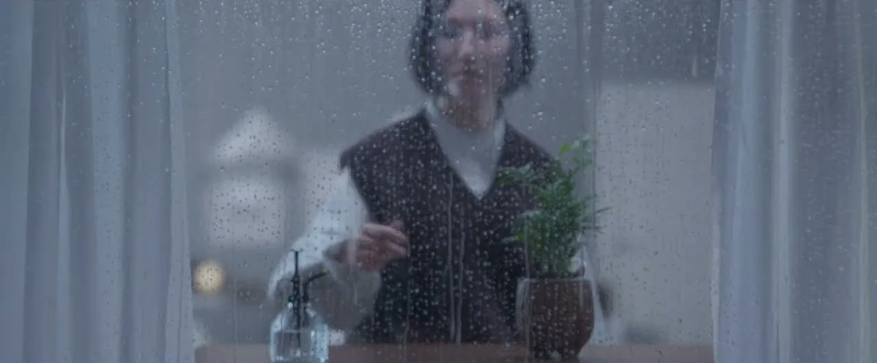 雨の窓越しの場面
